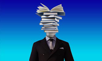 A stack of books forms the head of a person wearing a suit